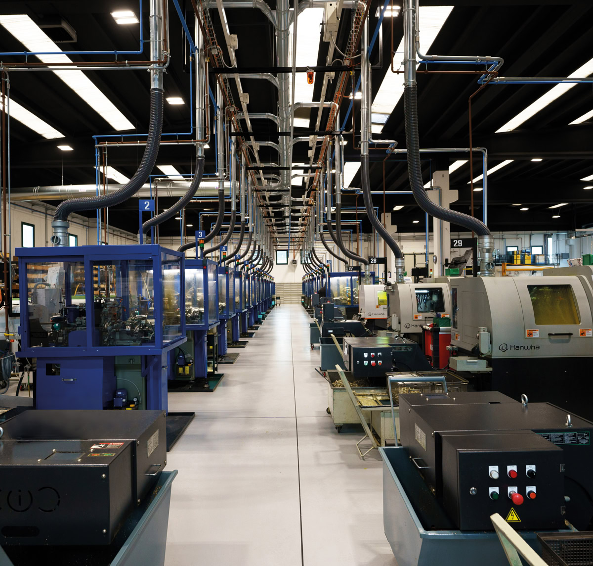 Production aisle lined with automatic lathes and Swiss-type CNC lathes with bar feeders at Eredi Baitelli