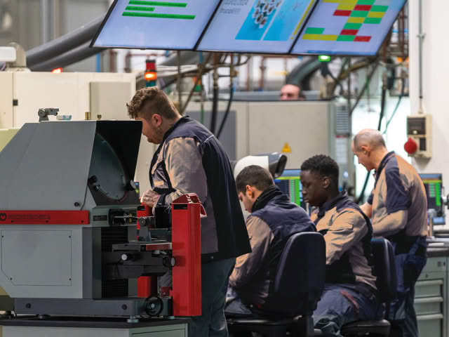 Operators at a profile projector and inspection workstations