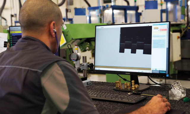 Operator checking a magnified part profile on an optical inspection system