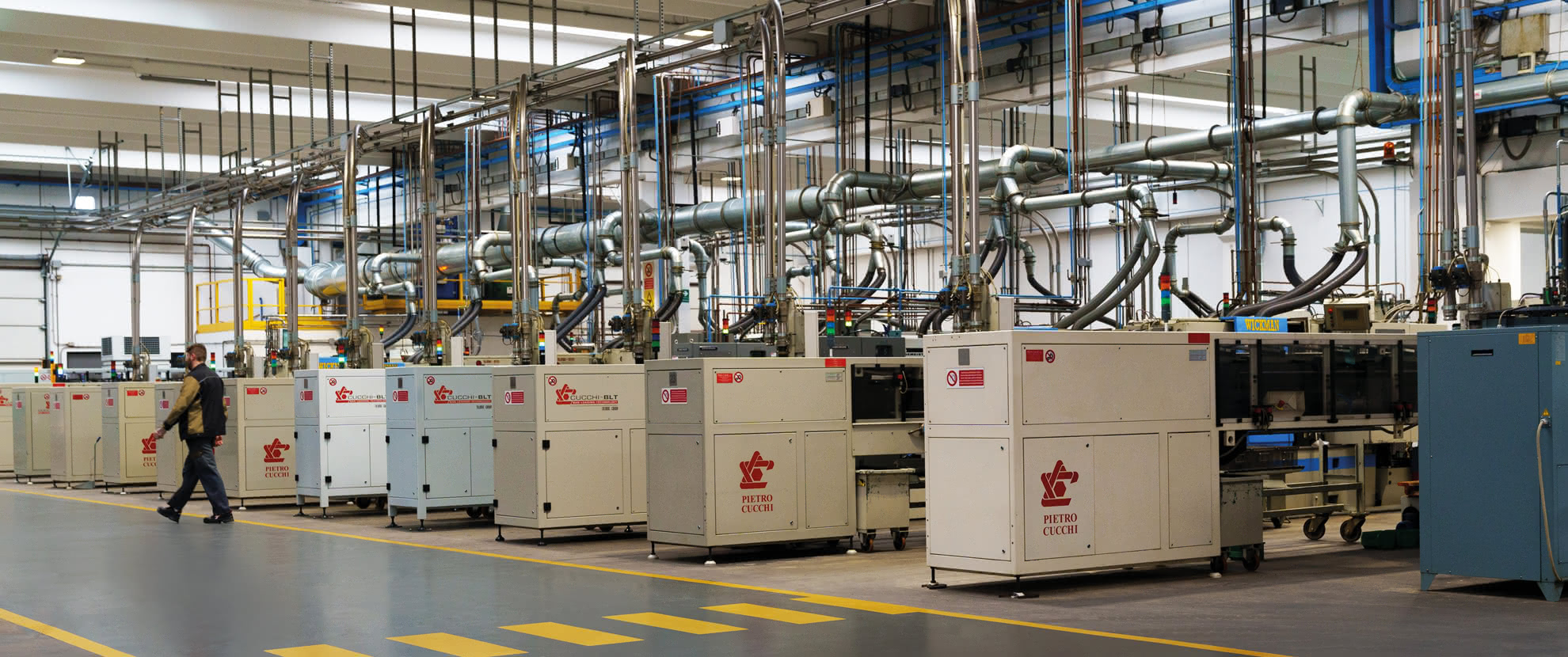 Pietro Cucchi multi-spindle automatic lathe line in the Eredi Baitelli production department, with centralized chip extraction and management systems.